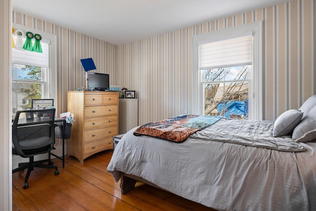 bedroom with wood-type flooring and wallpapered walls