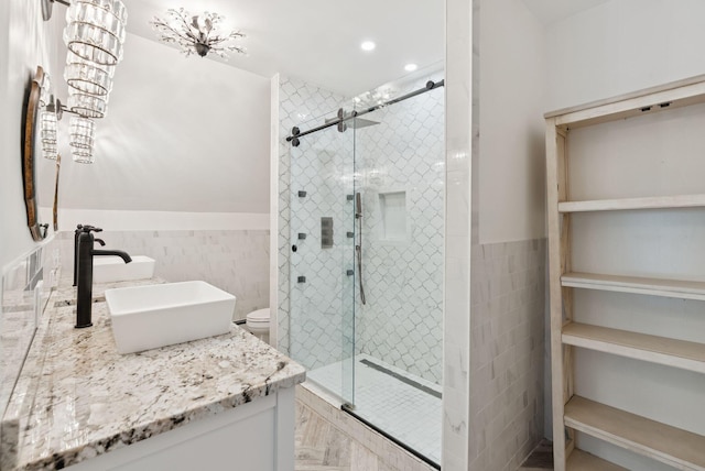 581 Bald Hill Rd, New Gloucester, ME 04260 - full bathroom with tile walls, double vanity, a shower stall, a wainscoted wall, and toilet