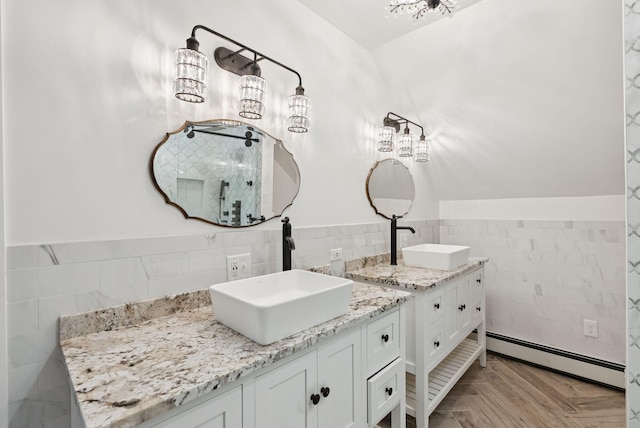 581 Bald Hill Rd, New Gloucester, ME 04260 - bathroom featuring a baseboard heating unit, tile walls, two vanities, and a wainscoted wall