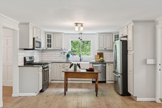 581 Bald Hill Rd, New Gloucester, ME 04260 - kitchen featuring appliances with stainless steel finishes, dark countertops, backsplash, light wood finished floors, and glass insert cabinets