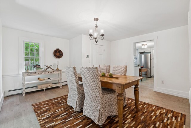 581 Bald Hill Rd, New Gloucester, ME 04260 - dining space featuring a chandelier, wood-type flooring, a baseboard heating unit, and baseboards