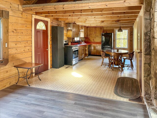 450 Greenwoods Rd, Peru, ME 04290 - kitchen with a sink, gas range, light floors, wood walls, and freestanding refrigerator