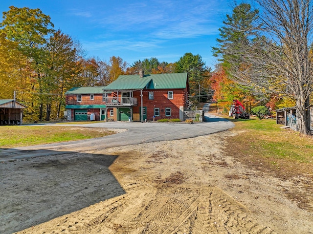450 Greenwoods Rd, Peru, ME 04290 - view of front of house with dirt driveway, a chimney, metal roof, a front yard, and a garage