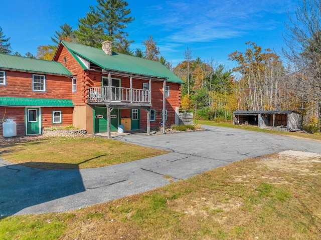 450 Greenwoods Rd, Peru, ME 04290 - log-style house featuring a front lawn, a balcony, a chimney, and metal roof