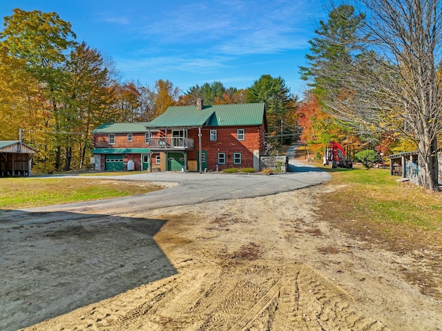 450 Greenwoods Rd, Peru, ME 04290 - view of front of property featuring a chimney, a front lawn, an attached garage, driveway, and metal roof
