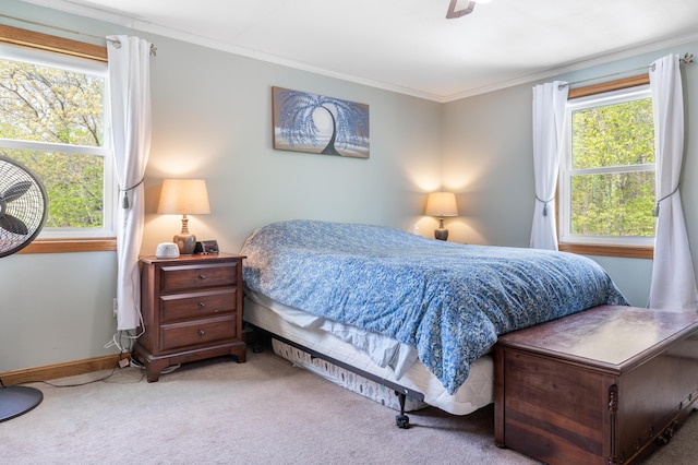 carpeted bedroom featuring ornamental molding, baseboards, and ceiling fan