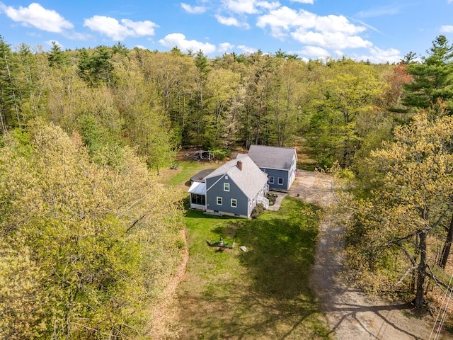 aerial view of property and surrounding area featuring a heavily wooded area