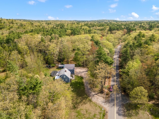 aerial view of property and surrounding area with a heavily wooded area