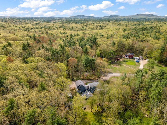aerial view of property and surrounding area with a heavily wooded area