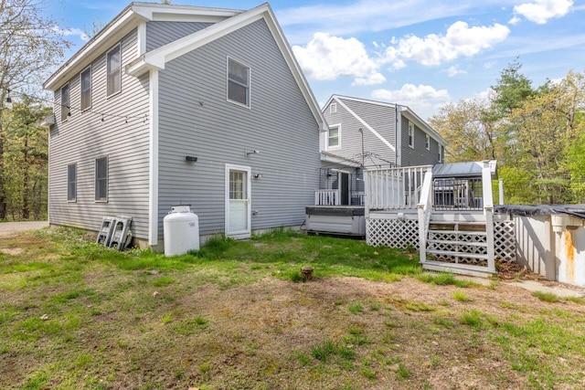 rear view of property with a deck and a lawn