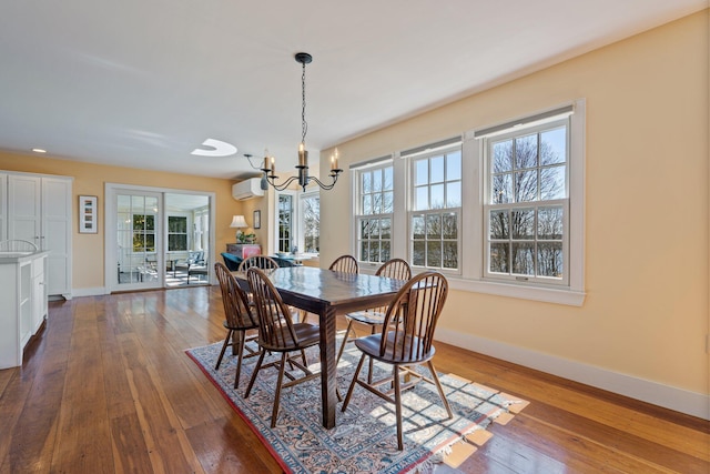 18 Pleasant St, Newcastle, ME 04553 - dining space featuring a wall mounted AC, baseboards, a chandelier, dark wood finished floors, and healthy amount of natural light