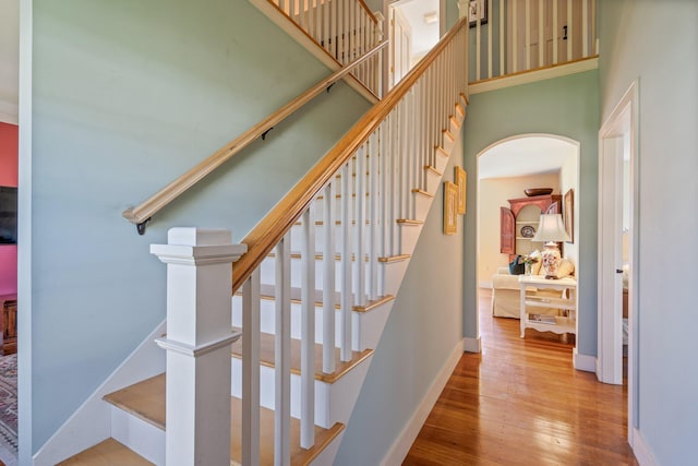 18 Pleasant St, Newcastle, ME 04553 - stairway with arched walkways, wood-type flooring, baseboards, and a high ceiling