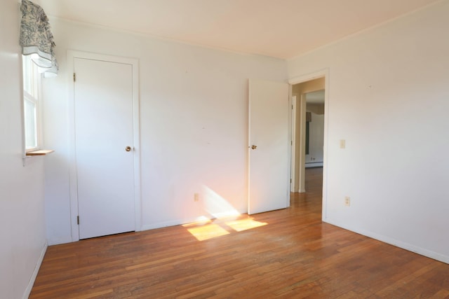 24 Lincoln St, Ellsworth, ME 04605 - unfurnished bedroom with a baseboard heating unit, hardwood / wood-style floors, and baseboards