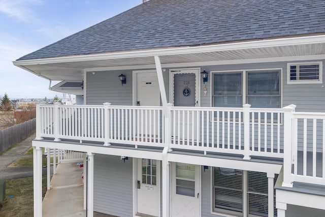 view of exterior entry featuring roof with shingles