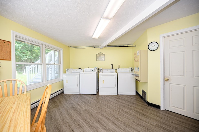 clothes washing area with washer and clothes dryer, laundry area, wood finished floors, and a textured ceiling