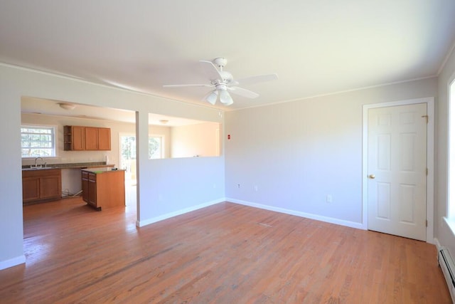 11 Foxtail Ln, Levant, ME 04456 - unfurnished living room featuring ceiling fan, a sink, baseboards, a baseboard heating unit, and light wood-style floors