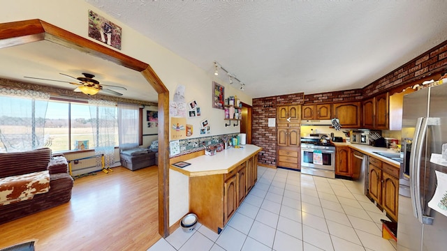 195 Rim Rd, East Machias, ME 04630 - kitchen with stainless steel appliances, light countertops, open floor plan, a ceiling fan, and brown cabinetry