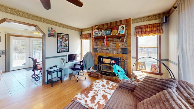 195 Rim Rd, East Machias, ME 04630 - living room featuring ceiling fan, wallpapered walls, a brick fireplace, wood finished floors, and french doors