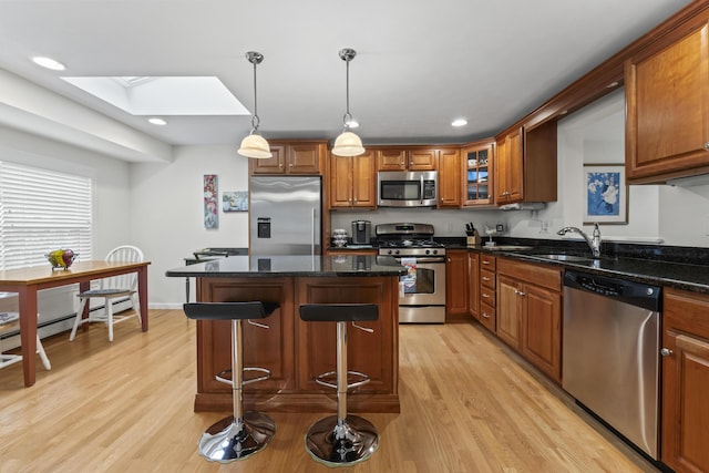 48 Windward Pointe Dr Unit 48, Wells, ME 04090 - kitchen featuring brown cabinetry, a sink, light wood-style floors, appliances with stainless steel finishes, and a skylight