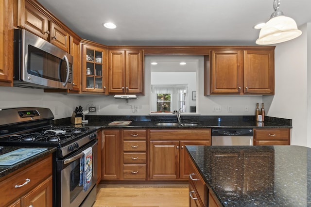 48 Windward Pointe Dr Unit 48, Wells, ME 04090 - kitchen with a sink, brown cabinetry, stainless steel appliances, light wood-type flooring, and glass insert cabinets