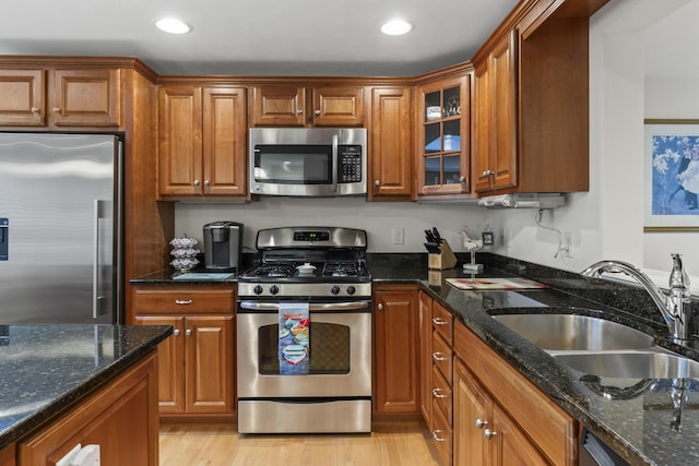 48 Windward Pointe Dr Unit 48, Wells, ME 04090 - kitchen with glass insert cabinets, brown cabinets, a sink, dark stone counters, and appliances with stainless steel finishes