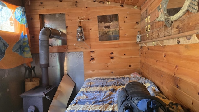 574 Half Township Rd, Lincoln, ME 04457 - bedroom featuring vaulted ceiling, wooden walls, and a wood stove