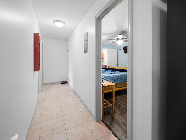 corridor featuring light tile patterned floors and baseboards