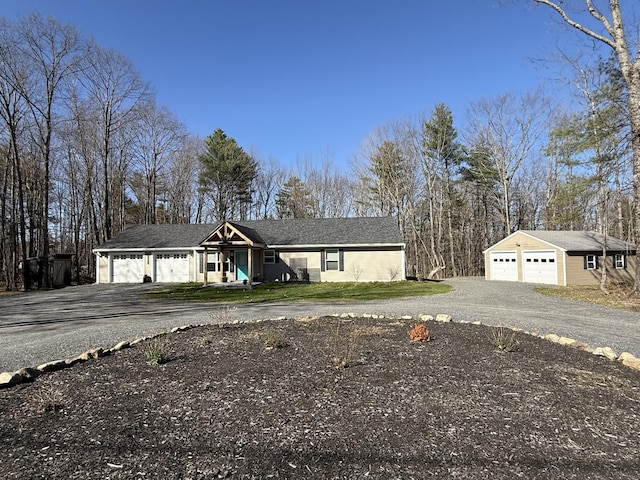 single story home featuring an outdoor structure, a garage, and driveway