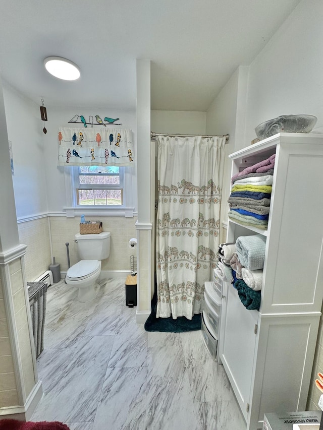 full bathroom featuring toilet, marble finish floor, baseboard heating, and curtained shower