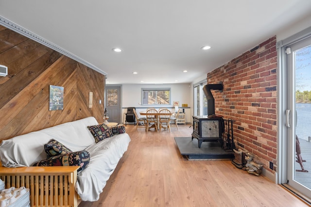 living area with recessed lighting, wood finished floors, and a wood stove