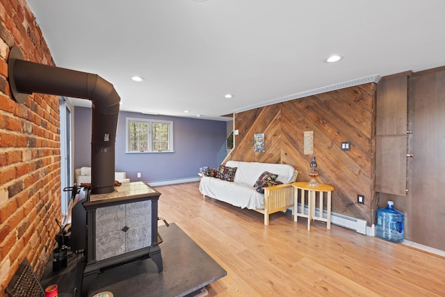 living room featuring recessed lighting, wood finished floors, a wood stove, and a baseboard radiator