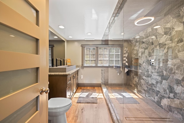 full bath featuring wood finished floors, a walk in shower, vanity, toilet, and recessed lighting