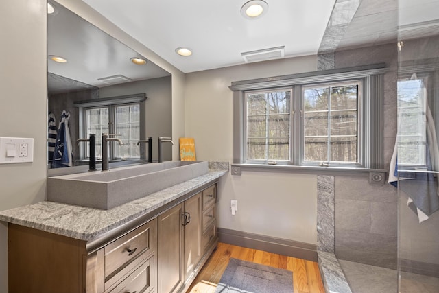 full bathroom featuring visible vents, wood finished floors, vanity, baseboards, and recessed lighting