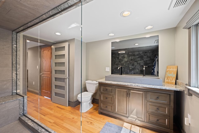 bathroom featuring visible vents, wood finished floors, vanity, toilet, and recessed lighting