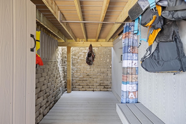 exterior space featuring brick wall and hardwood / wood-style flooring