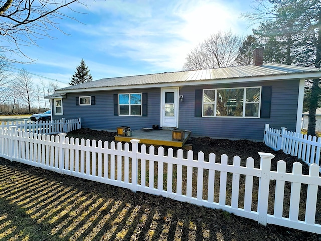6 Ridge Rd, Corinth, ME 04427 - single story home with a chimney, a deck, metal roof, and a fenced front yard