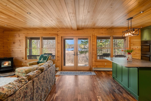 interior space featuring wooden ceiling, a wood stove, and plenty of natural light