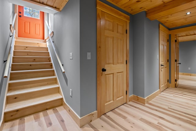 stairway featuring wooden ceiling, wood finished floors, and baseboards