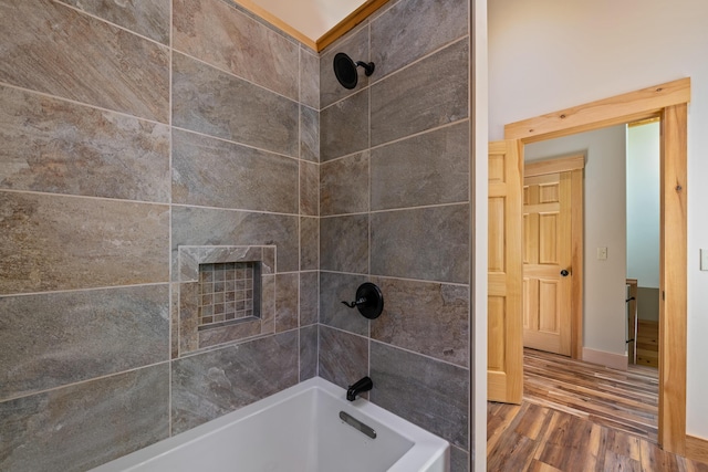 full bath featuring wood finished floors, baseboards, and bathing tub / shower combination