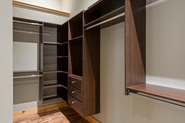 walk in closet with wood finished floors