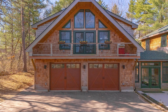 exterior space with french doors, aphalt driveway, and an attached garage