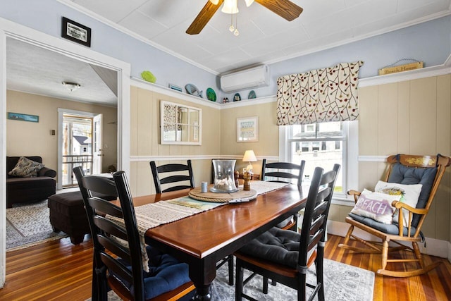 15 Longwood Ave, Old Orchard Beach, ME 04064 - dining area featuring a ceiling fan, ornamental molding, a wall unit AC, and wood finished floors