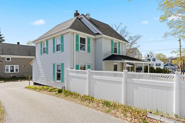 15 Longwood Ave, Old Orchard Beach, ME 04064 - view of home's exterior featuring fence, a chimney, and roof with shingles