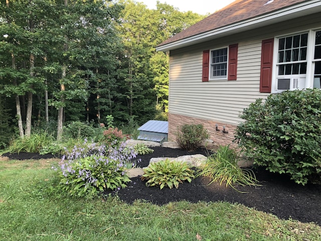 view of home's exterior featuring roof with shingles and cooling unit