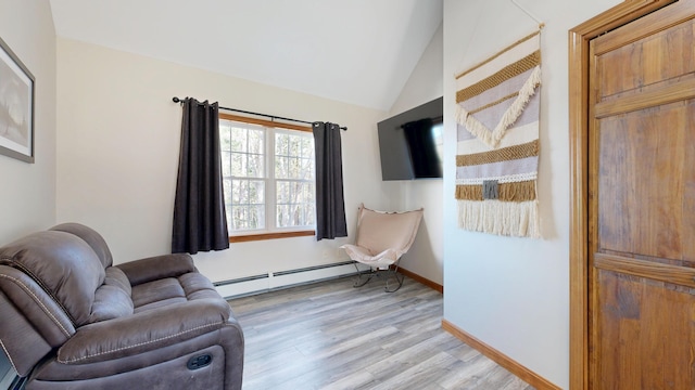 sitting room featuring light wood-style floors, baseboards, lofted ceiling, and a baseboard heating unit