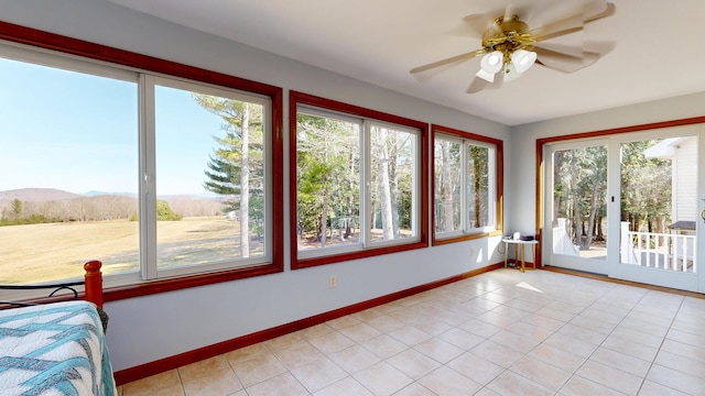 unfurnished sunroom featuring baseboards, a mountain view, tile patterned flooring, and french doors