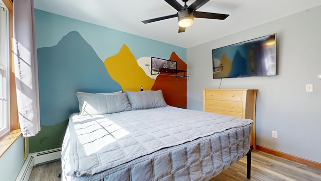 bedroom with baseboards, ceiling fan, a baseboard heating unit, and wood finished floors