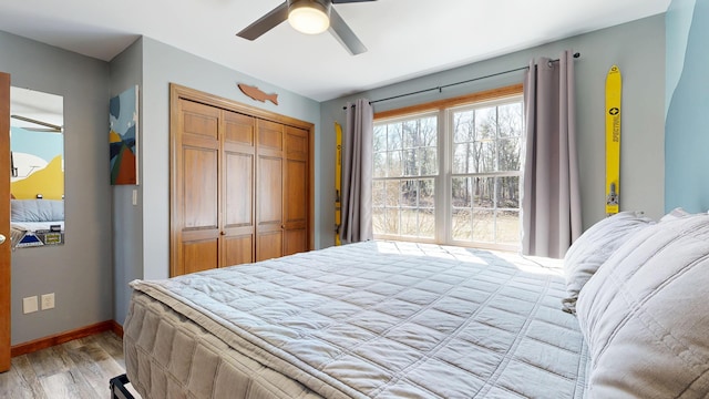 bedroom with a closet, baseboards, a ceiling fan, and light wood-type flooring
