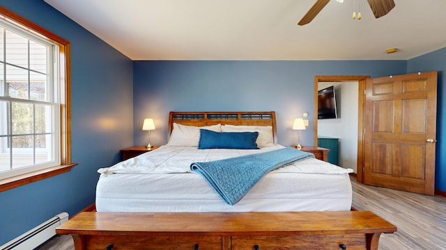 bedroom with baseboards, ceiling fan, baseboard heating, and wood finished floors