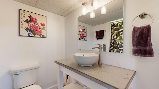 bathroom with vanity, a drop ceiling, and toilet